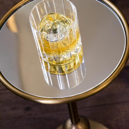 Photo d'un verre de whisky posé sur une table en verre