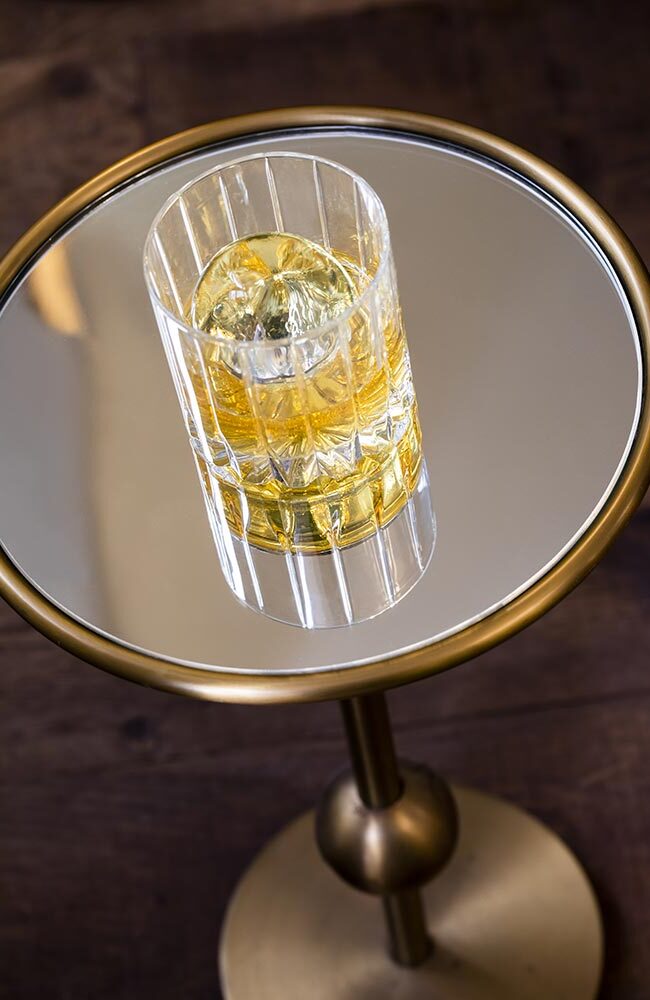 Photo d'un verre de whisky posé sur une table en verre