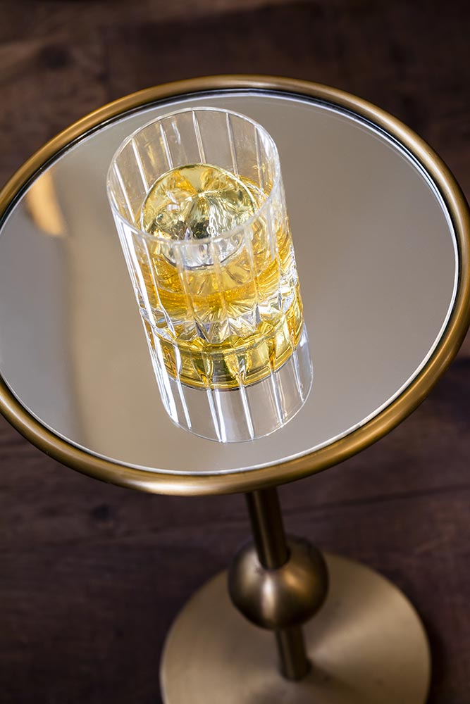 Photo d'un verre de whisky posé sur une table en verre